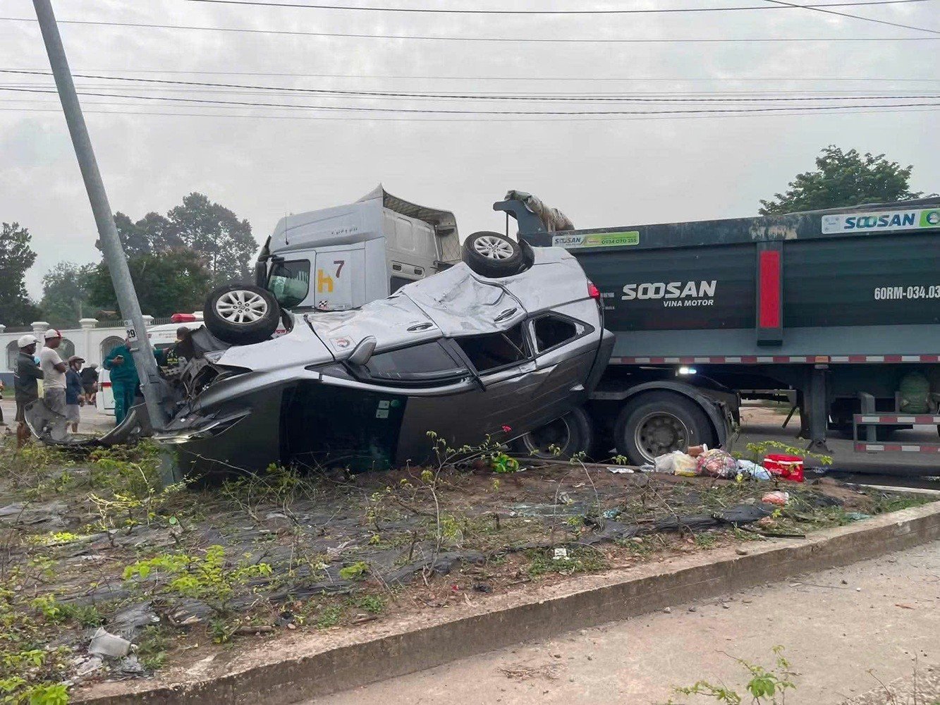 Ô tô 7 chỗ lật ngửa sau va chạm xe ben, người dân phá cửa cứu nạn